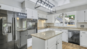 A contemporary kitchen in Richmond Hill, featuring stainless steel appliances, granite countertops, and white cabinetry.