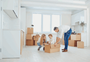 Family packing boxes for a move after selling their hom